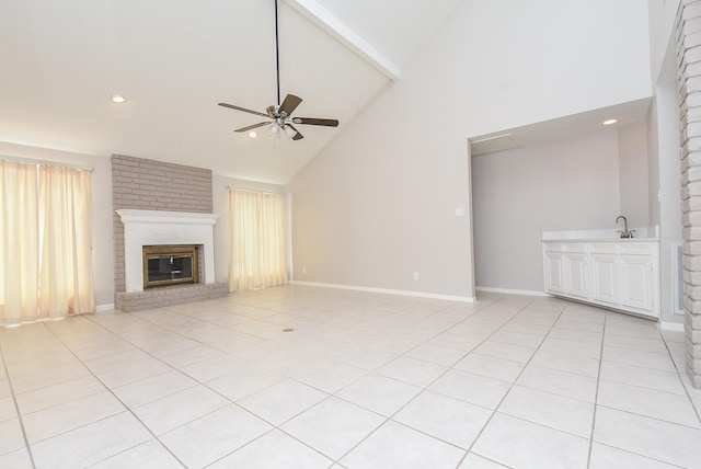 unfurnished living room with ceiling fan, a fireplace, high vaulted ceiling, and light tile patterned floors