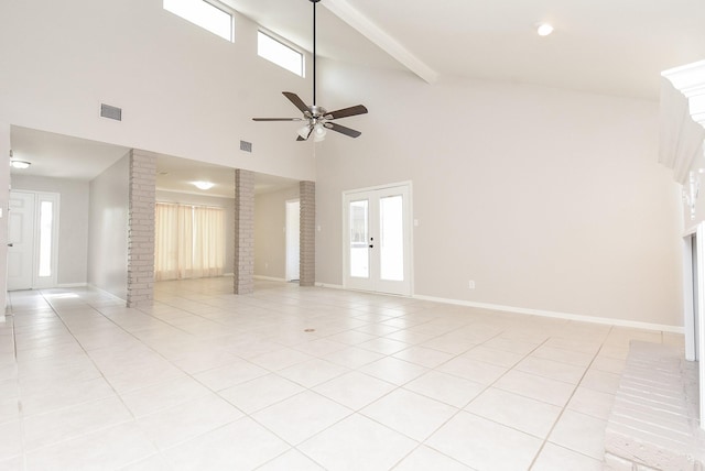 unfurnished living room featuring decorative columns, ceiling fan, light tile patterned floors, and a healthy amount of sunlight