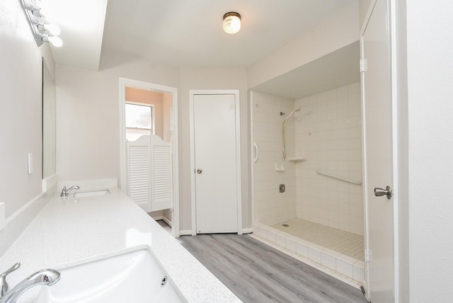 bathroom featuring tiled shower, hardwood / wood-style floors, and vanity