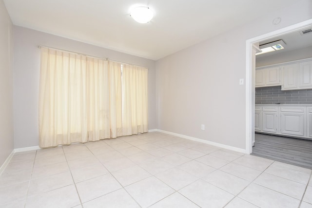 unfurnished room featuring light tile patterned flooring