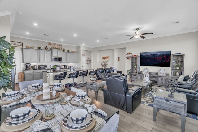 dining space with ceiling fan and ornamental molding