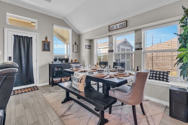 dining space featuring lofted ceiling and ornamental molding