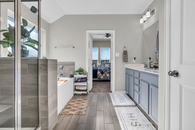 bathroom featuring a tub to relax in, crown molding, vanity, and ceiling fan