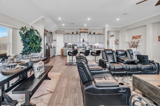 living room featuring lofted ceiling, ceiling fan, and ornamental molding