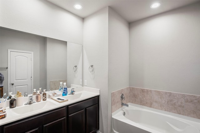 bathroom with vanity and a bath