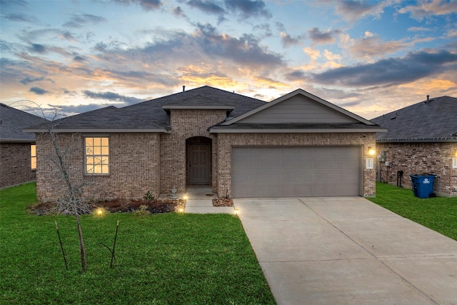 ranch-style home featuring a garage and a lawn