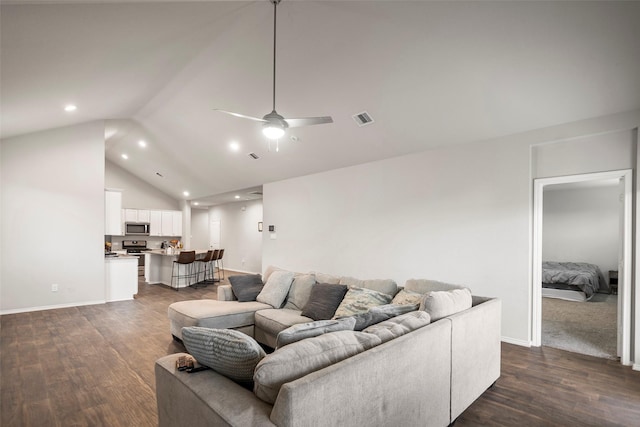 living room featuring ceiling fan, dark hardwood / wood-style flooring, and vaulted ceiling