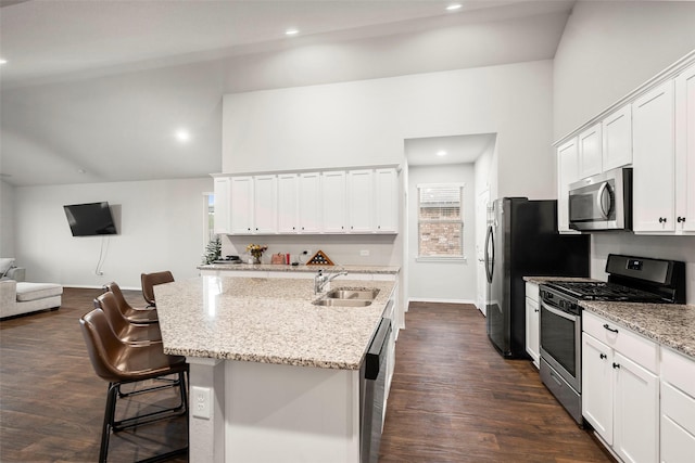 kitchen featuring white cabinets, sink, stainless steel appliances, and a breakfast bar area