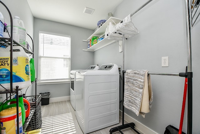 washroom featuring washer and clothes dryer and light wood-type flooring