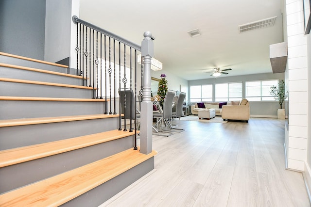 stairway featuring hardwood / wood-style flooring and ceiling fan