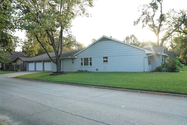 view of side of property with a lawn and a garage