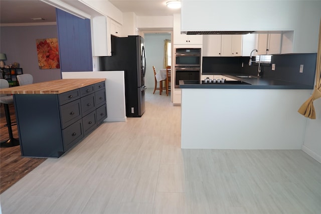 kitchen with white cabinetry, sink, kitchen peninsula, a breakfast bar area, and appliances with stainless steel finishes