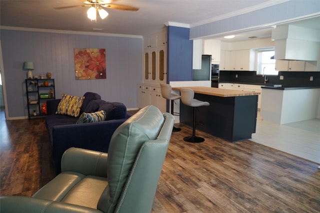 living room featuring sink, dark hardwood / wood-style flooring, ceiling fan, and ornamental molding