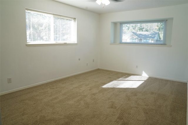 spare room featuring carpet flooring, plenty of natural light, and ceiling fan