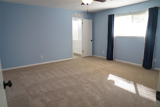 unfurnished bedroom featuring ceiling fan, light colored carpet, and a textured ceiling