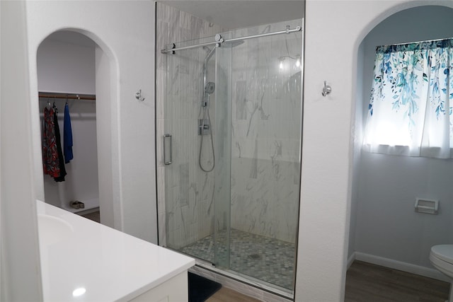 bathroom with vanity, toilet, an enclosed shower, and wood-type flooring