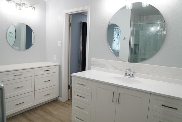 bathroom with vanity, wood-type flooring, and a shower with shower door