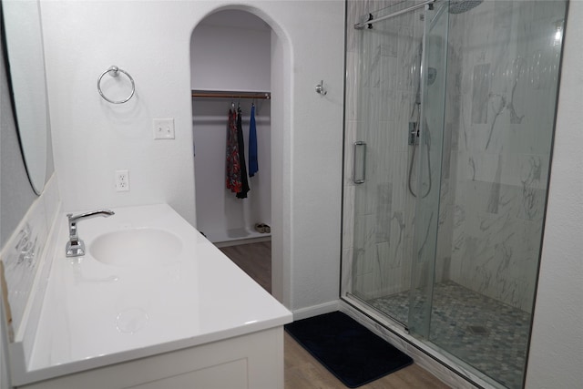 bathroom with hardwood / wood-style flooring, vanity, and walk in shower