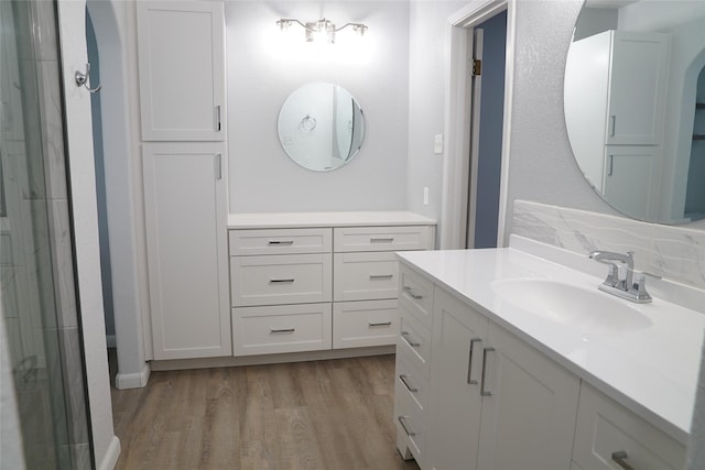 bathroom featuring hardwood / wood-style floors, vanity, and a shower with door