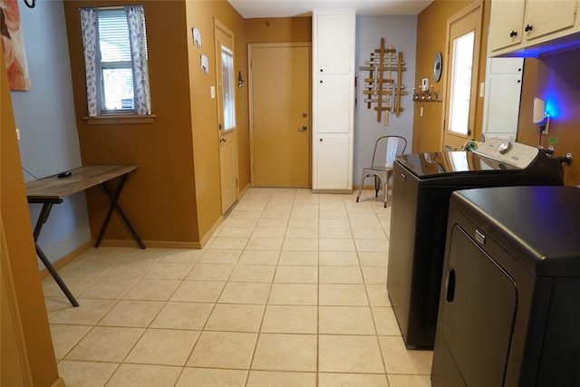 laundry room featuring cabinets, independent washer and dryer, and light tile patterned floors