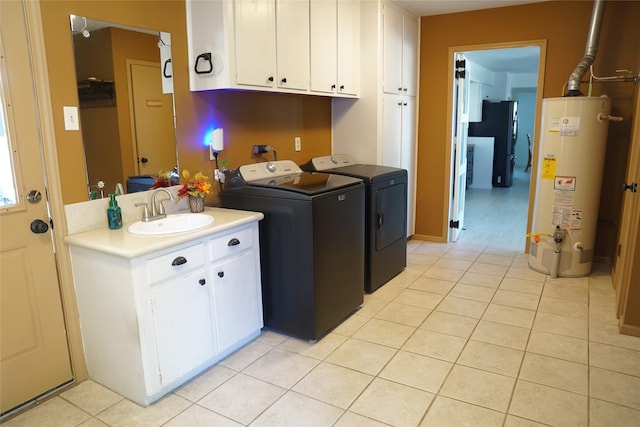 laundry room with cabinets, gas water heater, sink, light tile patterned floors, and independent washer and dryer