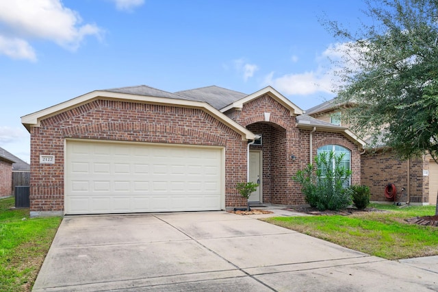 view of front of property with central AC unit and a garage