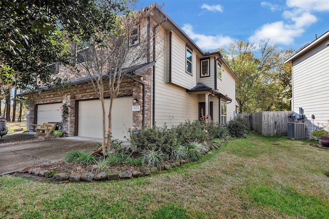 view of home's exterior with central air condition unit, a lawn, and a garage