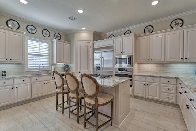 kitchen featuring built in appliances, decorative backsplash, a center island, and white cabinets