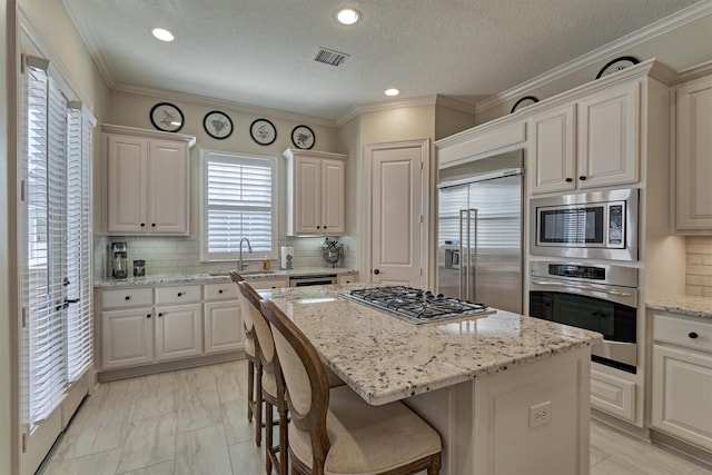 kitchen featuring built in appliances, a center island, and tasteful backsplash