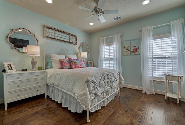 bedroom with a textured ceiling, dark hardwood / wood-style floors, and ceiling fan