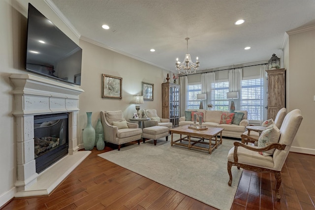 living room featuring hardwood / wood-style floors, ornamental molding, a textured ceiling, and a chandelier