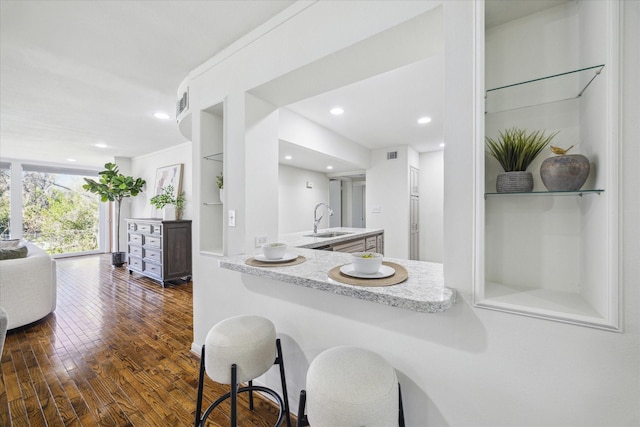 kitchen with built in shelves, dark hardwood / wood-style flooring, and sink