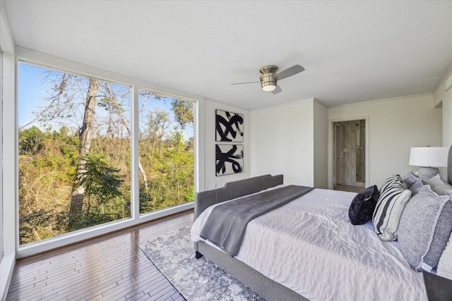 bedroom featuring ceiling fan, wood-type flooring, and ornamental molding