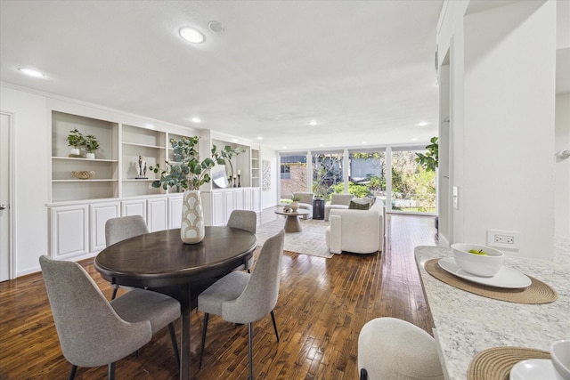 dining room featuring built in shelves, dark hardwood / wood-style flooring, and floor to ceiling windows