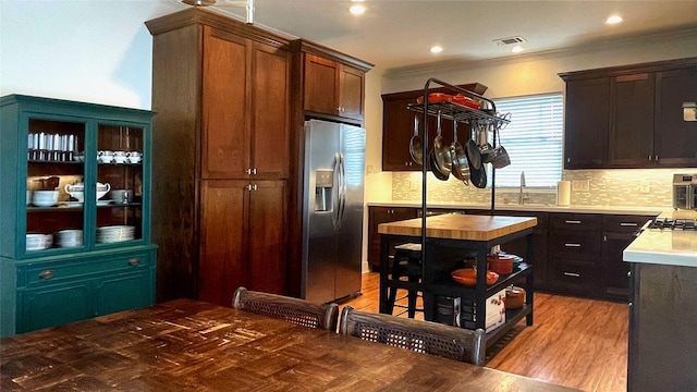 kitchen with sink, stainless steel appliances, light hardwood / wood-style flooring, crown molding, and decorative backsplash