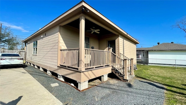 view of home's exterior featuring ceiling fan, a yard, and covered porch