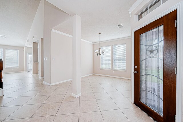 foyer featuring plenty of natural light, light tile patterned floors, and an inviting chandelier