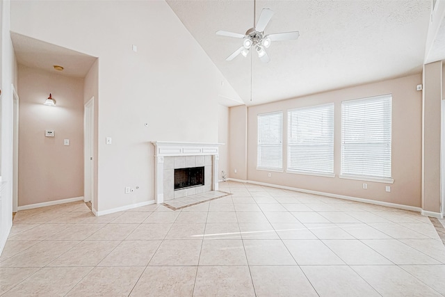 unfurnished living room featuring light tile patterned flooring, a textured ceiling, ceiling fan, high vaulted ceiling, and a tiled fireplace