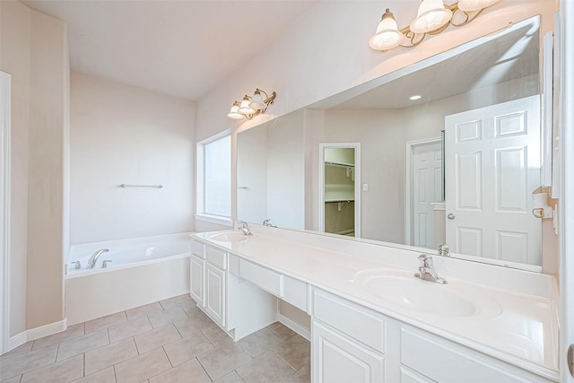 bathroom featuring a bathtub, vanity, and tile patterned flooring