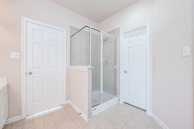 bathroom featuring tile patterned floors, vanity, and a shower with door