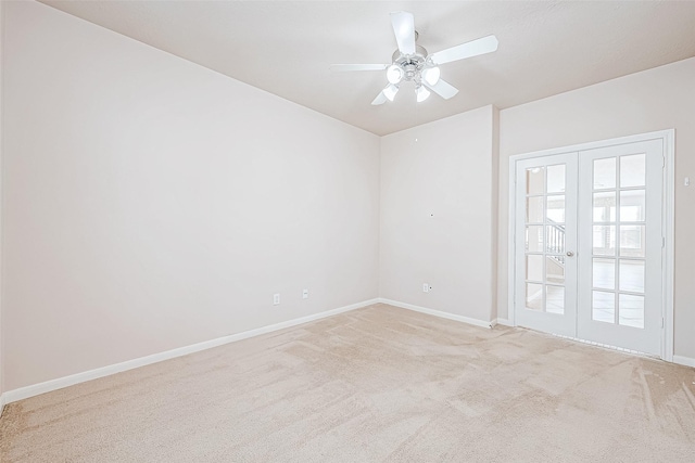 empty room featuring ceiling fan, light colored carpet, and french doors