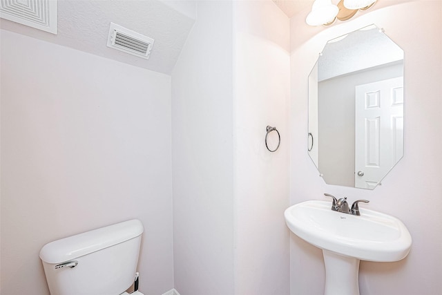 bathroom featuring sink, toilet, and a textured ceiling