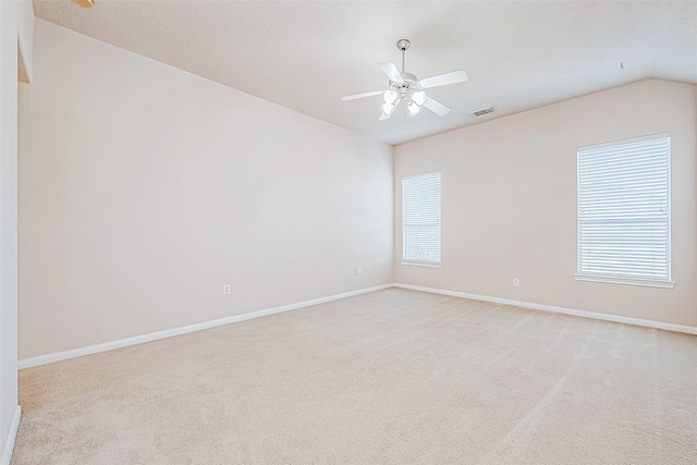 carpeted empty room with ceiling fan and vaulted ceiling