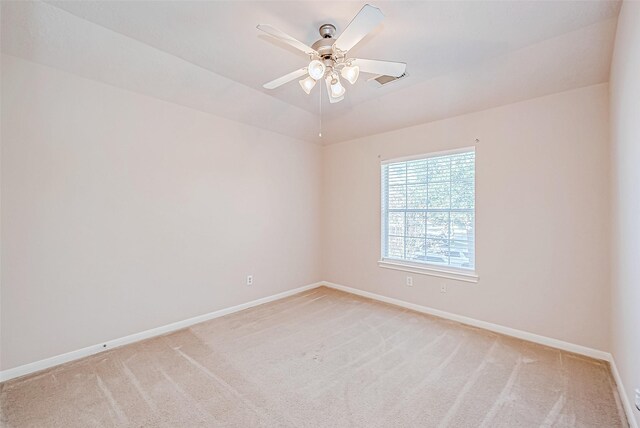 carpeted spare room with ceiling fan and vaulted ceiling