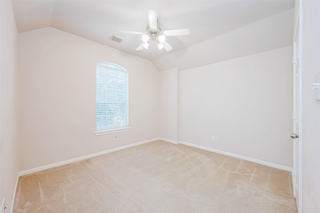 carpeted empty room with vaulted ceiling and ceiling fan