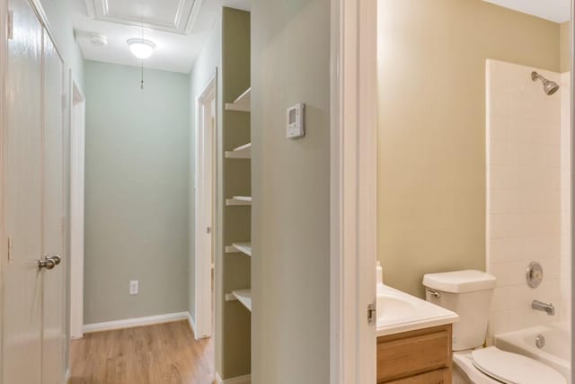 full bathroom featuring hardwood / wood-style floors, vanity, toilet, and tiled shower / bath combo