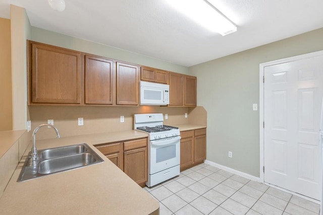 kitchen with white appliances, sink, and light tile patterned floors