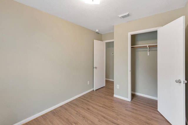 unfurnished bedroom featuring light wood-type flooring and a closet