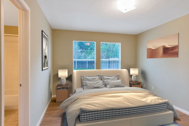 bedroom featuring hardwood / wood-style floors and ensuite bathroom