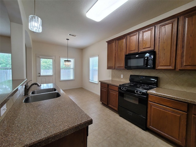 kitchen featuring decorative light fixtures, sink, tasteful backsplash, and black appliances